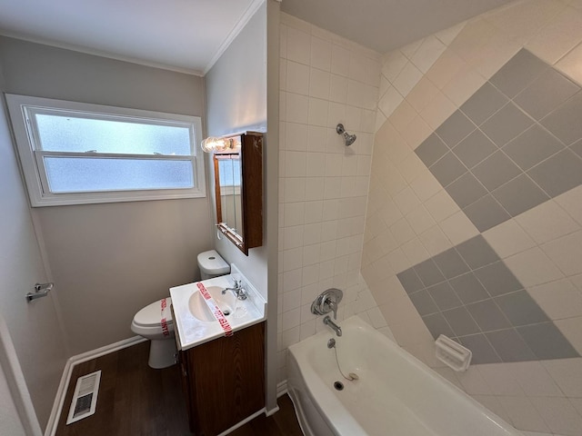 full bathroom with crown molding, hardwood / wood-style floors, toilet, vanity, and tiled shower / bath