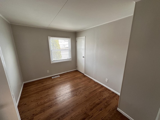 unfurnished room with dark hardwood / wood-style flooring and ornamental molding