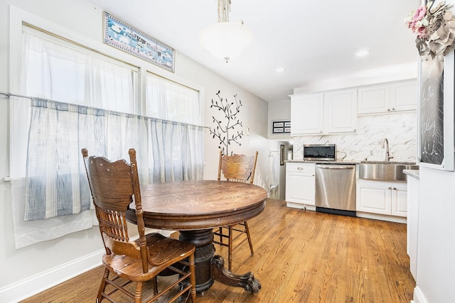 dining area with light hardwood / wood-style floors and sink