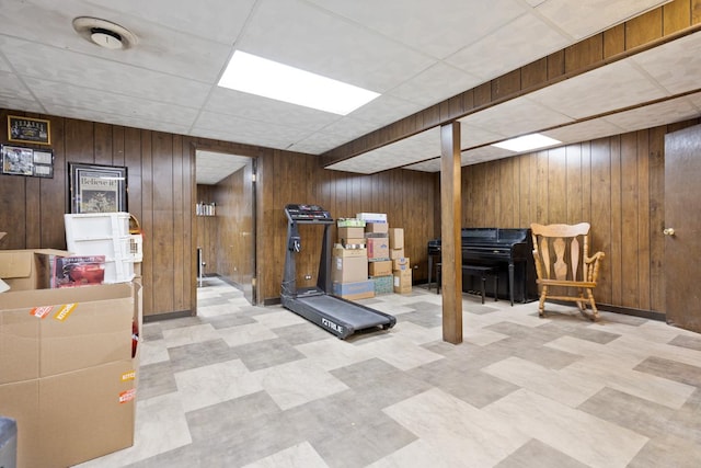 exercise area with a drop ceiling and wood walls