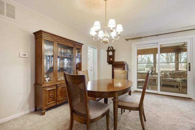 dining area with light colored carpet and an inviting chandelier