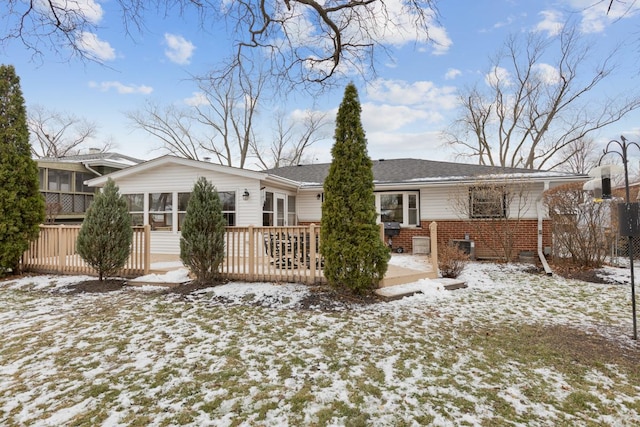 snow covered property featuring a sunroom