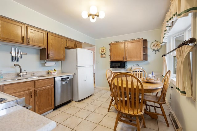 kitchen featuring dishwasher, an inviting chandelier, white refrigerator, sink, and light tile patterned flooring