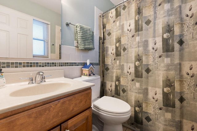 bathroom with vanity, toilet, walk in shower, and tasteful backsplash