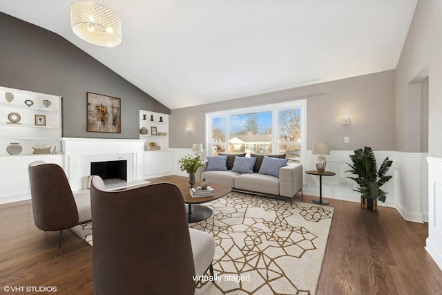 living room featuring built in features, a brick fireplace, dark wood-type flooring, and lofted ceiling