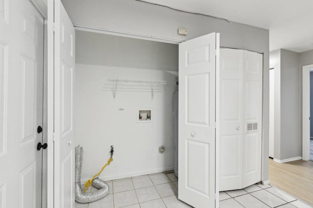 clothes washing area featuring light tile patterned floors and washer hookup