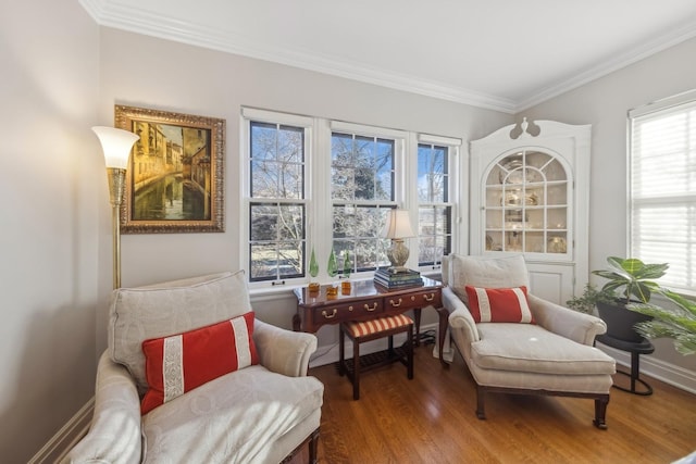 sitting room featuring wood-type flooring, ornamental molding, and a healthy amount of sunlight