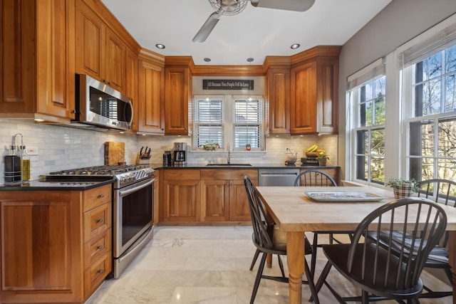 kitchen with sink, stainless steel appliances, backsplash, and ceiling fan