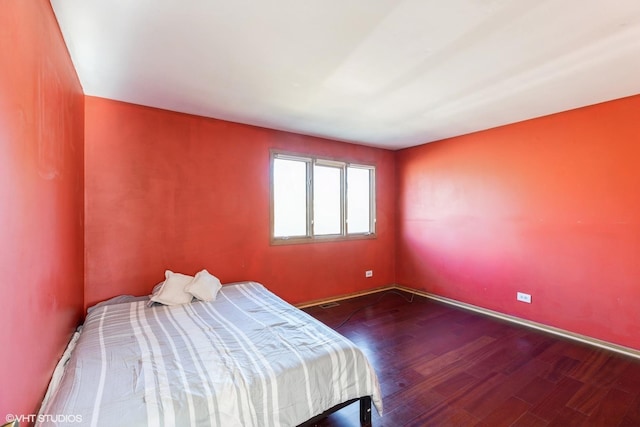 bedroom with dark hardwood / wood-style floors