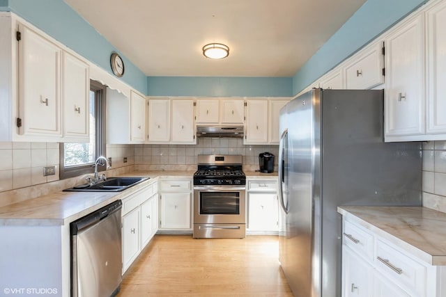 kitchen with sink, stainless steel appliances, light hardwood / wood-style flooring, decorative backsplash, and white cabinets