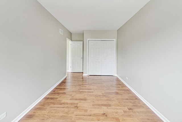 unfurnished bedroom featuring light hardwood / wood-style flooring and a closet