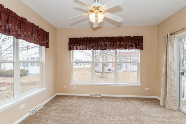 unfurnished dining area featuring plenty of natural light, light colored carpet, and ceiling fan