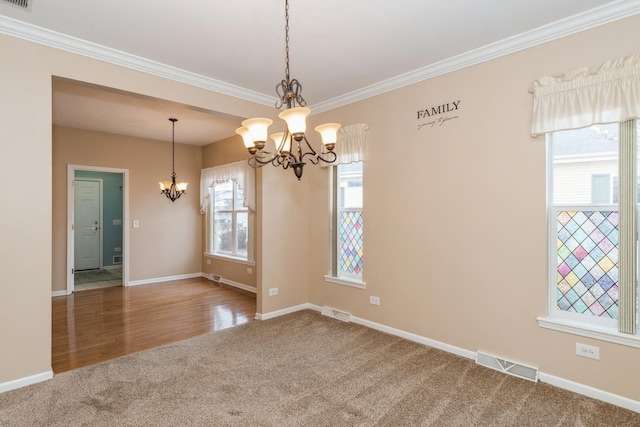 unfurnished room featuring crown molding, carpet flooring, and an inviting chandelier