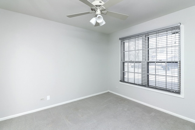 carpeted spare room with a wealth of natural light and ceiling fan