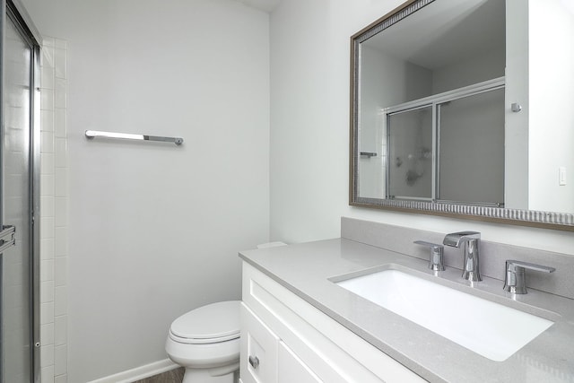 bathroom featuring vanity, toilet, and an enclosed shower