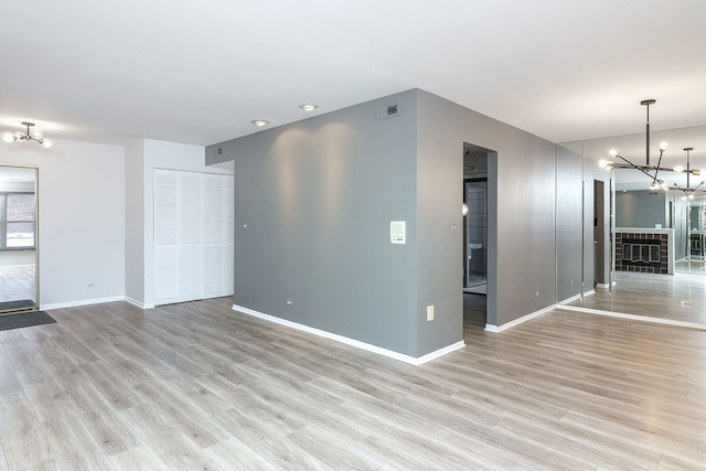 unfurnished room featuring light hardwood / wood-style floors and a notable chandelier