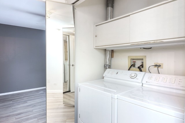 laundry area with light wood-type flooring and washing machine and clothes dryer