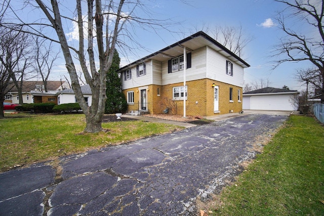 view of front facade featuring an outbuilding, a garage, and a front lawn