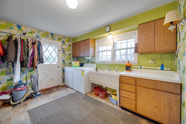 clothes washing area with cabinets and washing machine and dryer