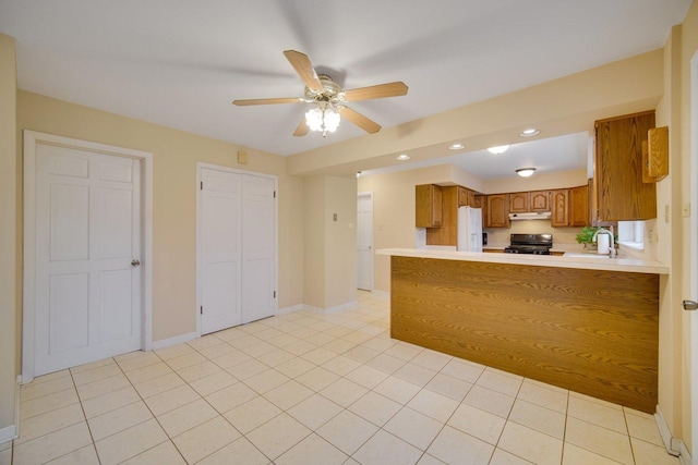 kitchen featuring kitchen peninsula, black range with gas stovetop, ceiling fan, sink, and white refrigerator with ice dispenser