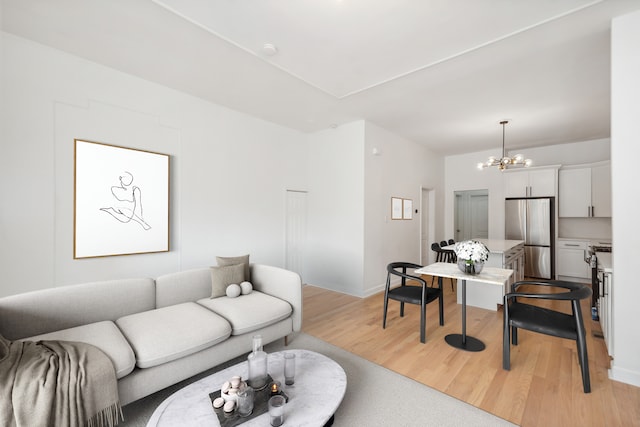 living room featuring a notable chandelier and light hardwood / wood-style flooring