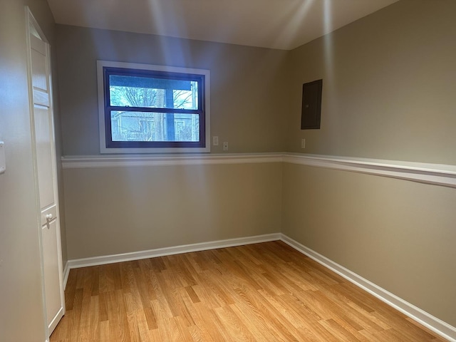 empty room featuring electric panel and light hardwood / wood-style floors