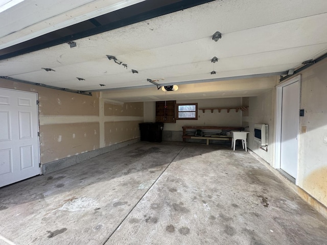 garage featuring heating unit and a garage door opener