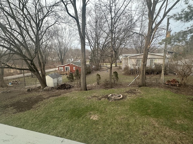 view of yard with a fire pit and a storage shed