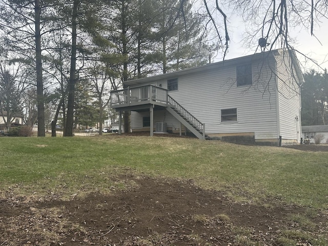 back of property featuring a wooden deck and a lawn