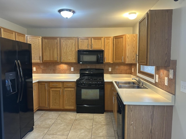 kitchen featuring decorative backsplash, sink, light tile patterned flooring, and black appliances