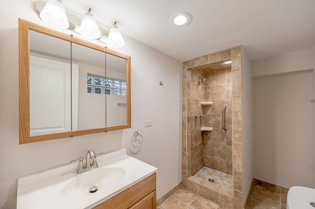 bathroom featuring a tile shower and vanity