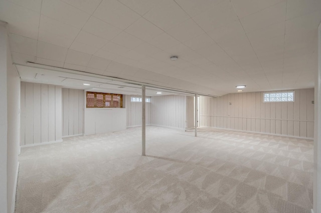 basement with light carpet and wooden walls