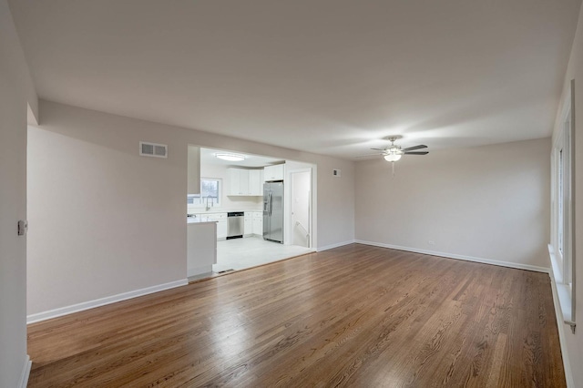 unfurnished living room featuring light hardwood / wood-style flooring and ceiling fan