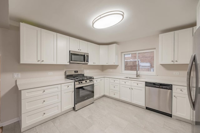 kitchen with sink, white cabinetry, and stainless steel appliances