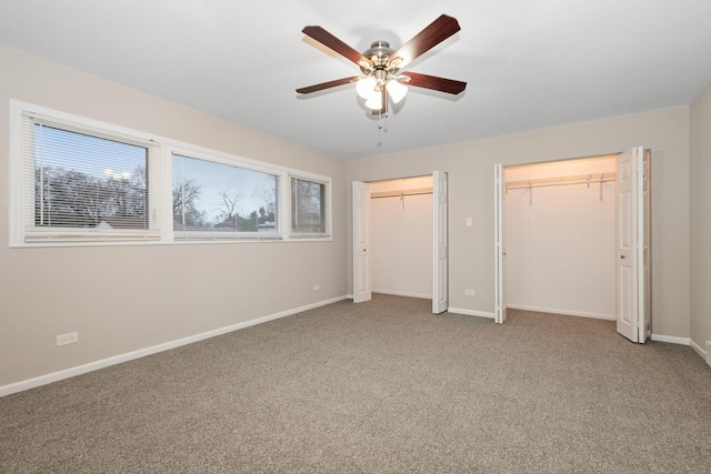 unfurnished bedroom featuring carpet floors, two closets, and ceiling fan