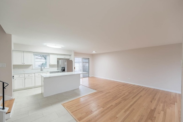 kitchen featuring a center island, sink, plenty of natural light, white cabinetry, and stainless steel fridge with ice dispenser