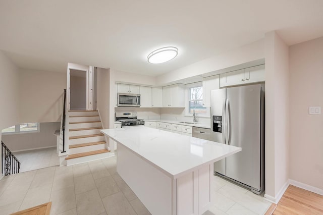 kitchen featuring white cabinetry, sink, a kitchen island, and stainless steel appliances