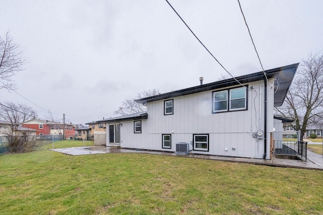 rear view of property with a patio area, a yard, and central AC