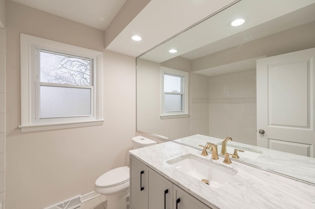 bathroom with vanity, toilet, and a wealth of natural light