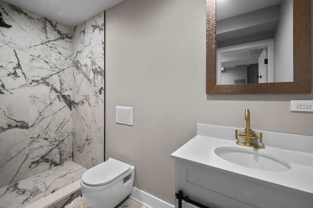 bathroom with toilet, vanity, and tiled shower