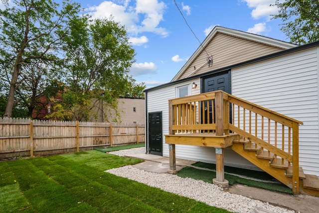 back of property with a lawn and a wooden deck