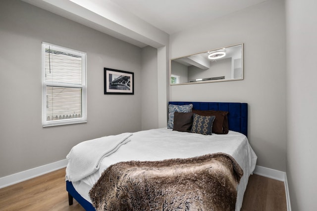 bedroom with wood-type flooring and multiple windows