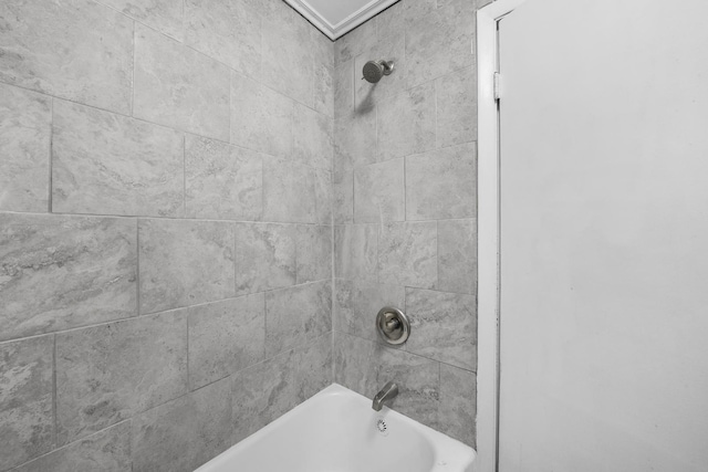 bathroom featuring crown molding and tiled shower / bath combo