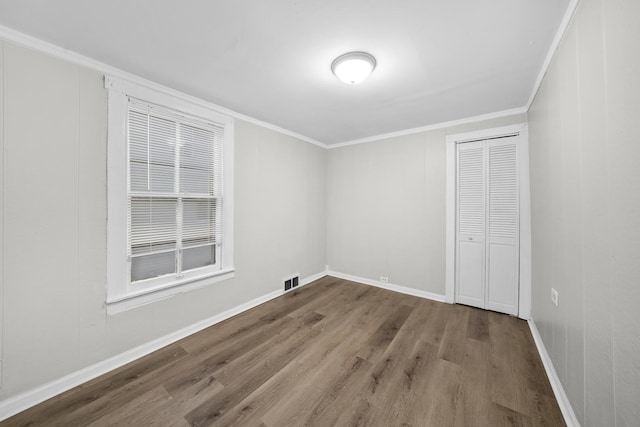 spare room featuring wood-type flooring and ornamental molding