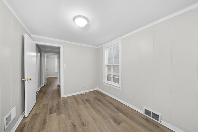 unfurnished room with hardwood / wood-style floors and ornamental molding