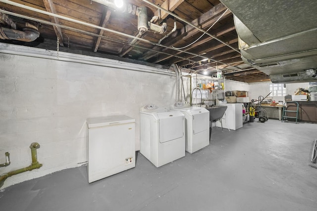 basement featuring washing machine and clothes dryer and fridge