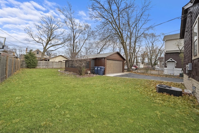 view of yard featuring a garage, an outbuilding, and central AC