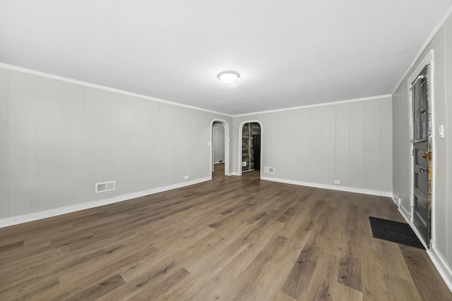 empty room featuring hardwood / wood-style floors and crown molding