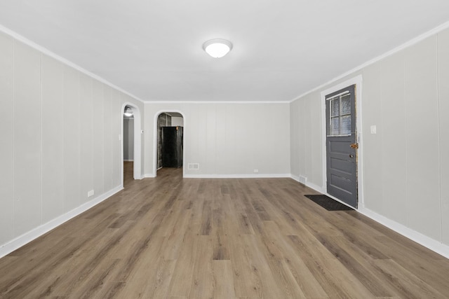 unfurnished room featuring wood-type flooring and ornamental molding