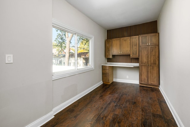 kitchen with dark hardwood / wood-style flooring and built in desk